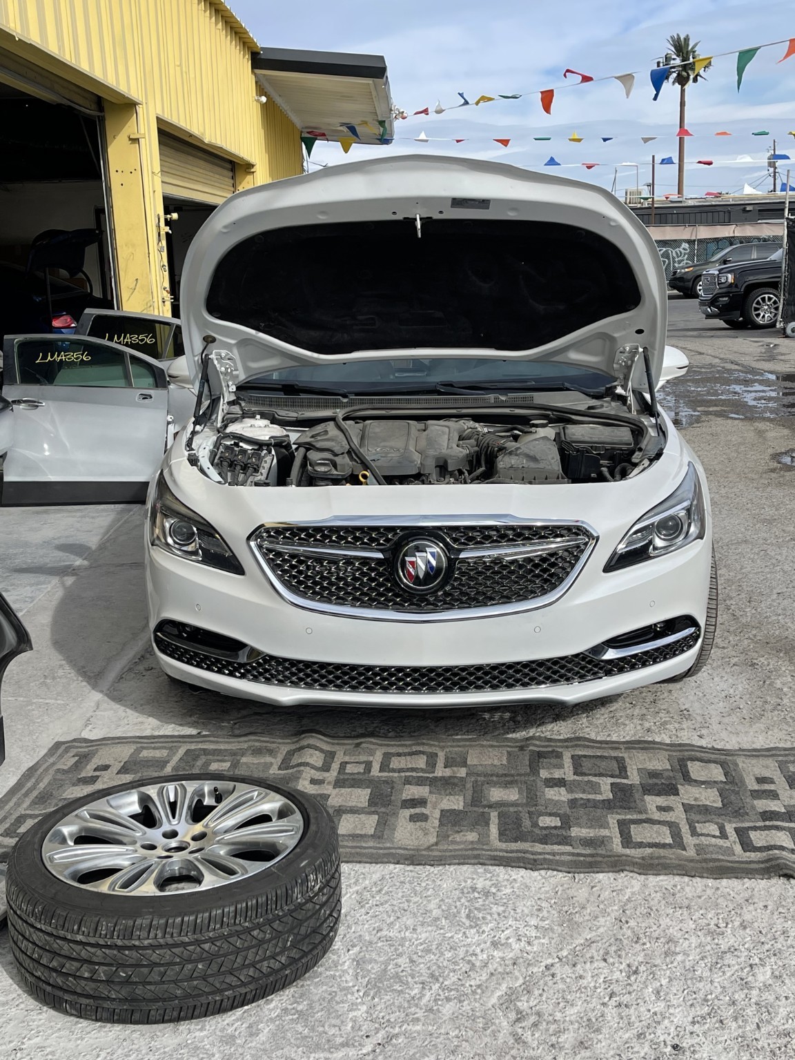 After Repair: owner-confirmed photograph of the white Buick front with bumper and grille fitted, hood raised
